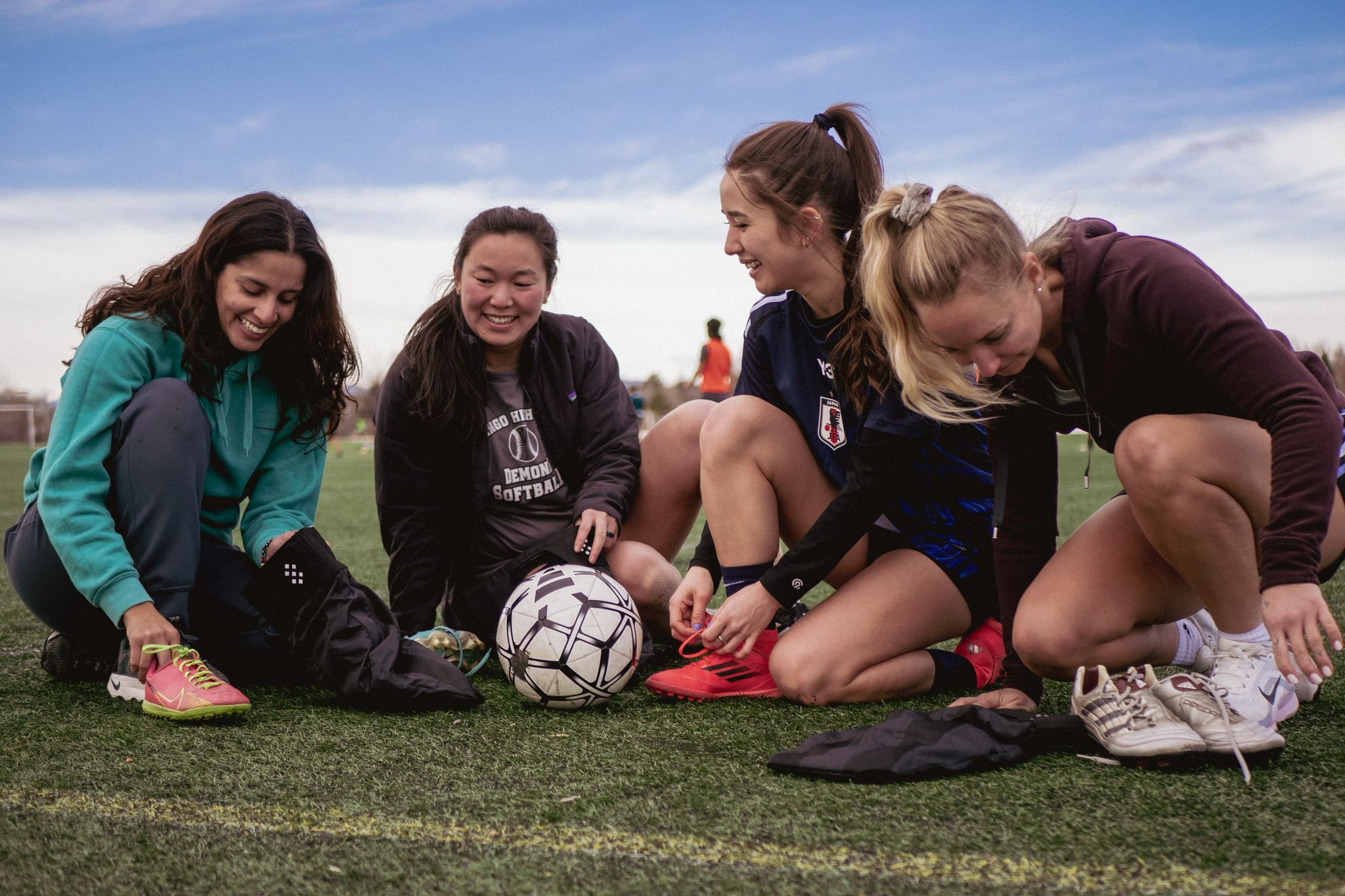Players kneeling around a ball on grass