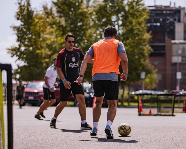 Pickup game in orange bibs on asphalt